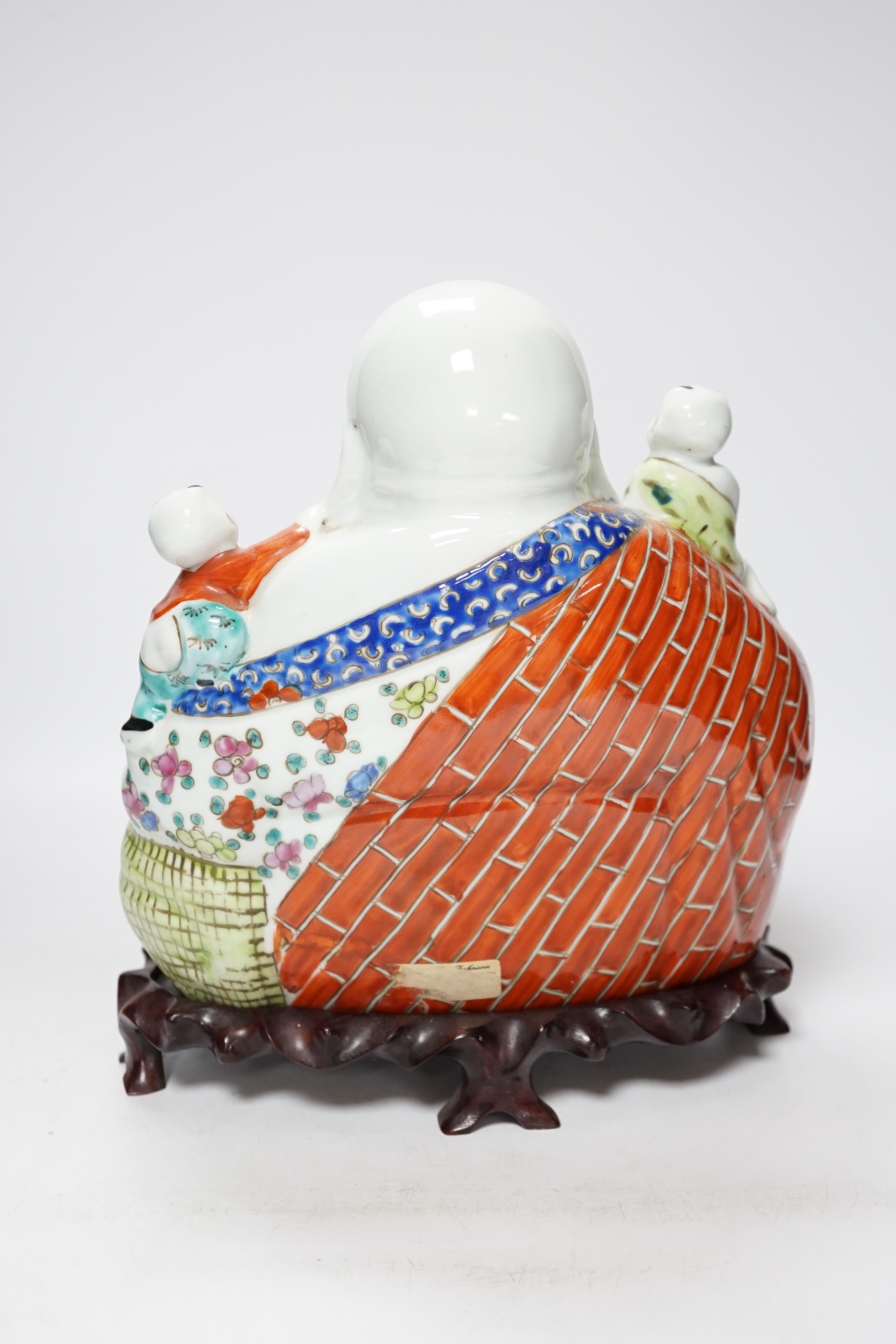 A 20th century Chinese porcelain Buddha on hardwood stand, 28cm